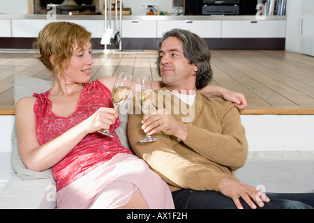 Ein paar auf einem Sofa sitzt und Toasten mit Champagner Stockfoto