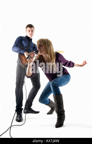 Studioaufnahme eines Mannes spielt e-Gitarre und eine Frau, die in ein Mikrofon singen Stockfoto