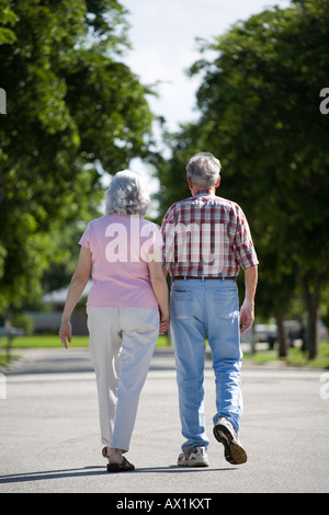 Ein älteres paar zu Fuß entlang einer Straße Stockfoto