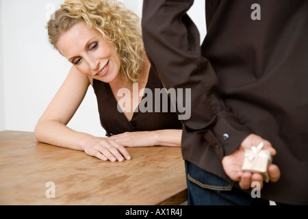 Eine Frau, die derzeit in die Hände des Mannes spähen Stockfoto