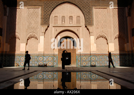 Menschliche Silhouetten im orientalisch gestalteten harmonische Hof mit Wasserteich Ali Ben Youssef Medersa Medina Marrakesch Marokko Stockfoto