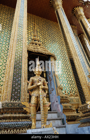 Goldene Wache am Eingang von Hor Phra Gandhararat Pagode, Wat Pra Kaeo Tempel, Bangkok, Thailand Stockfoto