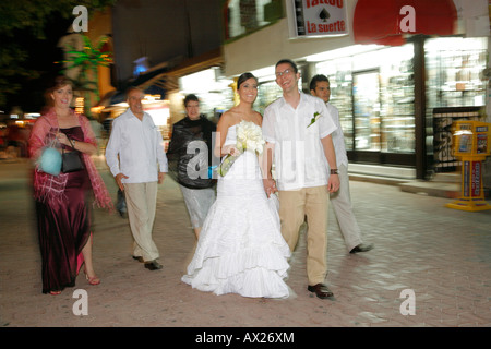 Hochzeitspaar zu Fuß auf einer Straße nach der kirchlichen Trauung, Playa del Carmen, Mexiko Stockfoto