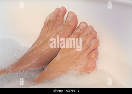 Sonnenlicht auf Zehen einweichen in der Badewanne, mit Luftblasen Stockfoto