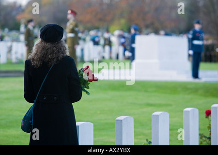Eine Dame, einen Strauß Rosen, mit Uhren die Gedenktag Gedenkfeiern am Stonefall Friedhof, Harrogate, England. Stockfoto