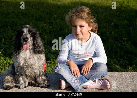 Sechs Jahre altes Kind sitzen auf einer Bank mit ihrem Hund Stockfoto
