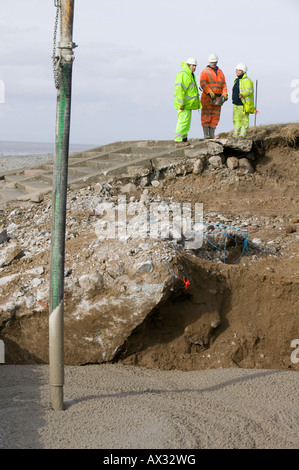 Reparatur ein Loch in der Straße in der Nähe von Allonby, Cumbria, verursacht durch extremen stürmen die Ufermauer wodurch es zum Einsturz zu untergraben Stockfoto