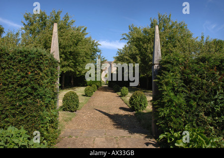 EIN PFAD, FLANKIERT VON ZWEI HÖLZERNEN SÄULEN IM GARTEN AM GUTSHOF SOMERSET VOM GARTEN DESIGNER SIMON JOHNSON UK Stockfoto