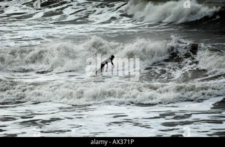 GENIEßT EINE SURFER IN VOLLER NEOPRENANZUG SURFEN IM FEBRUAR IN DER CHALLABOROUGH BUCHT, IN DER NÄHE VON BIGBURY AM MEER, ENGLAND, VEREINIGTES KÖNIGREICH. Stockfoto