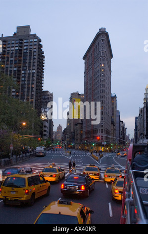 Flatiron Gebäude New York City, nachts mit gelben Taxis im Vordergrund Stockfoto