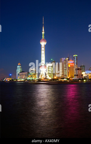 China, Shanghai, Pudong New Area. Der Oriental Pearl Tower und modernen Gebäuden am Ufer des Huangpu-Flusses beleuchtet. Stockfoto