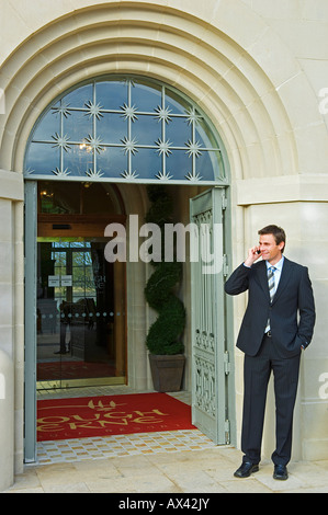 Großbritannien, Nordirland, Fermanagh, Enniskillen. Geschäftsmann am Handy am Lough Erne Golf Resort (MR). Stockfoto