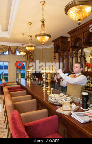 Nordirland, Fermanagh, Enniskillen. Ein Barkeeper gießt einen Pint Guinness in der Blaney Bar des Lough Erne Golf Resort (MR). Stockfoto