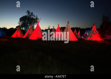 Eine Reihe von Tipis in der Abenddämmerung in einem englischen Feld Stockfoto