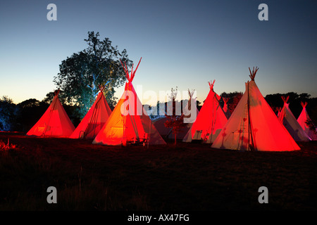 Eine Reihe von Tipis in der Abenddämmerung in einem englischen Feld Stockfoto