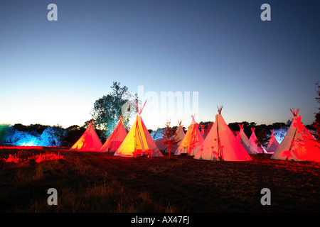 Eine Reihe von Tipis bei Sonnenuntergang in einem englischen Feld Stockfoto