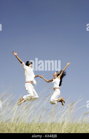 Seitenansicht eines jungen Paares in einem Park springen Stockfoto