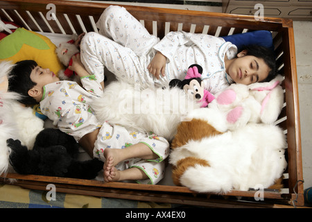 Erhöhte Ansicht eines jungen und seiner Schwester in einem Babybett schlafen Stockfoto