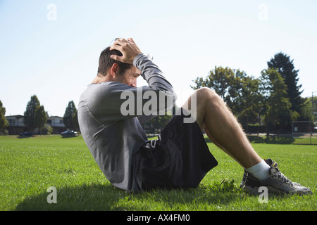 Mann tut Sit-ups im freien Stockfoto