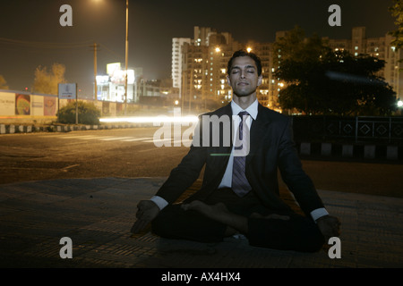 Geschäftsmann üben Yoga am Straßenrand Stockfoto