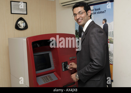 Porträt eines Geschäftsmannes Bank ATM-Automaten und lächelnd Stockfoto