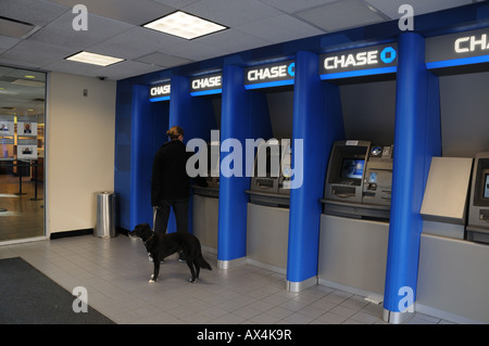 Ein Kunde nutzt ein Geldautomat in einer Manhattan Bank. Stockfoto