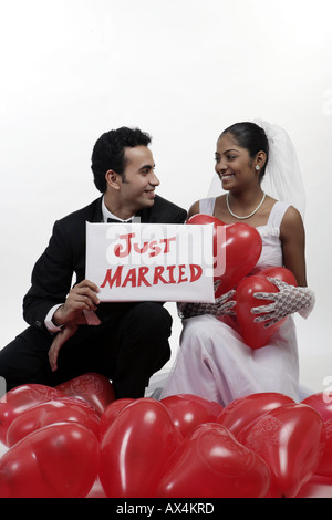 Frisch verheiratetes Paar zeigt Plakat Stockfoto