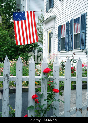 Weißen Lattenzaun rote Rosen und amerikanische Flagge am 4. Juli in Rockport, Massachusetts Stockfoto