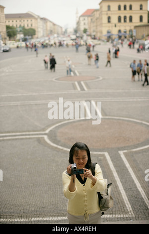 Asiatische Frau, die an Ort und Stelle mit einer Kamera in der Hand, selektiven Fokus Stockfoto