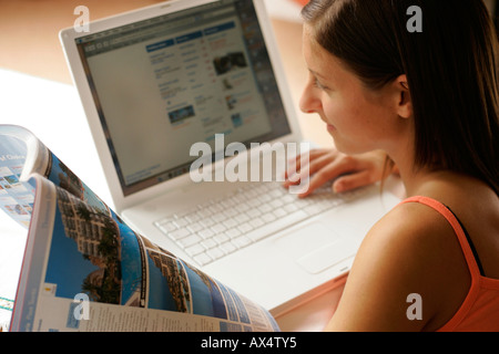 Frau auf der Suche nach Urlaub im Internet Stockfoto