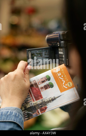 Hand mit einem Flyer und eine Kamera, Nahaufnahme, selektiven Fokus Stockfoto