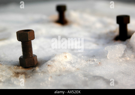 Drei verrosteten Schrauben im Schnee eingefroren Stockfoto