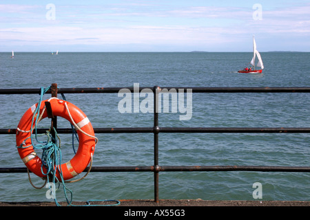 Rettungsring Aufhängen am Geländer am Strand bei Whitehead, County Antrim, Nordirland Stockfoto