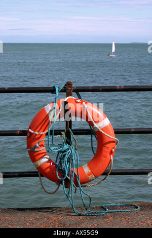 Rettungsring Aufhängen am Geländer am Strand bei Whitehead, County Antrim, Nordirland Stockfoto