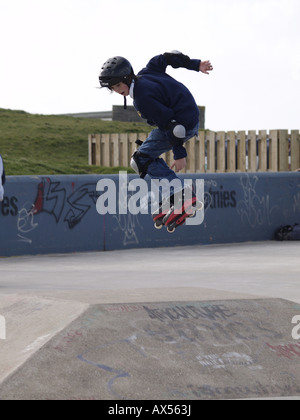 Junge auf Rollerblades, Tricks zu machen Stockfoto