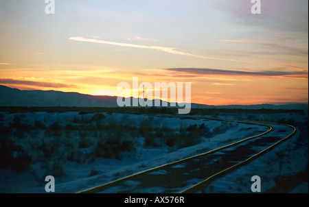 Einen wunderschönen Winter Sonnenuntergang in Salt Lake City, Utah, USA mit einem Satz verfolgt der alten Eisenbahn gehen aus in den Sonnenuntergang Horizont. Stockfoto