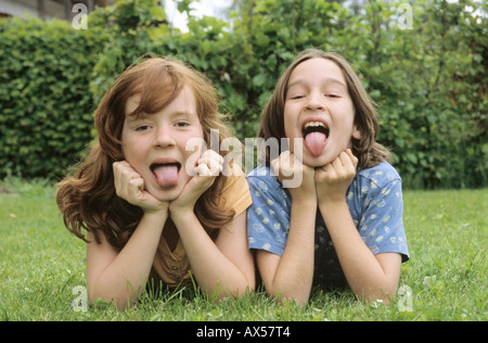 Kinder liegen in der Wiese im Garten, Porträt Stockfoto