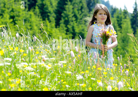 Mädchen mit Blumen im Sommerwiese Stockfoto