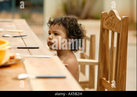 Kleines Kind am Tisch warten auf Essen, Asuncion, Paraguay, Südamerika Stockfoto
