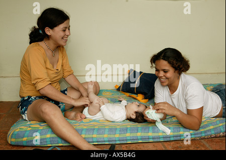 Zwei junge Frauen, die Änderung des Babys Windel, Asuncion, Paraguay, Südamerika Stockfoto