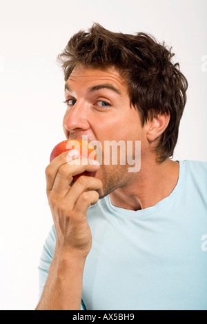 Junger Mann Essen Apfel, Porträt, Nahaufnahme Stockfoto