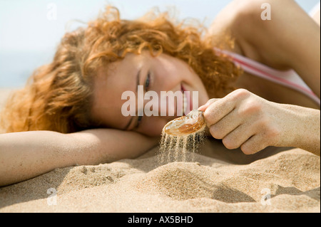 Junge Frau am Strand, mit Schale Stockfoto