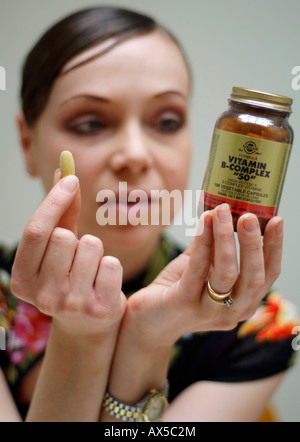 Eine junge Frau, die Nahrungsergänzungsmittel Stockfoto