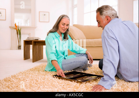 Älteres Paar spielen Backgammon im Wohnzimmer Stockfoto