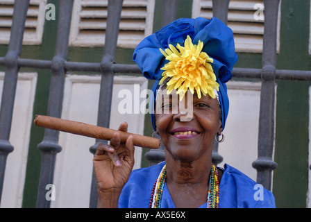 Frau trägt traditionelle Kleidung mit einer Zigarre, Havanna, Kuba Stockfoto