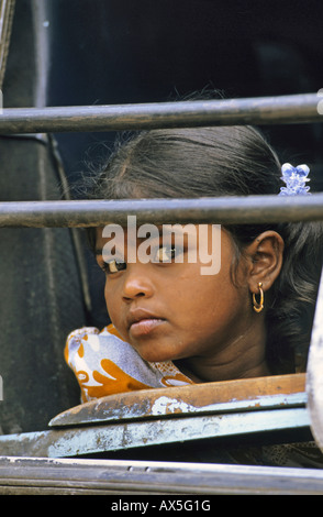 Junge Mädchen, die aus vergitterten Busfenster, Indien Stockfoto