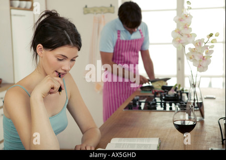 Frau arbeitet in der Küche, Mann Kochen Stockfoto