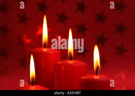 Brennende Kerze vor Rot Weihnachten Geschenkpapier mit Sternen Stockfoto
