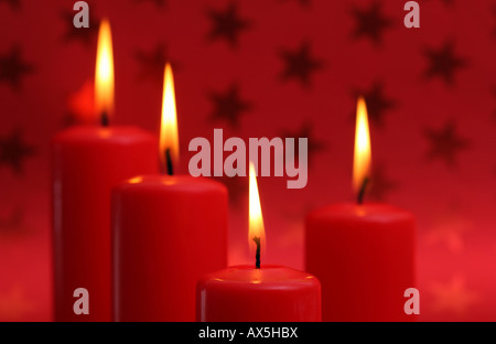Brennende Kerze vor Rot Weihnachten Geschenkpapier mit Sternen Stockfoto