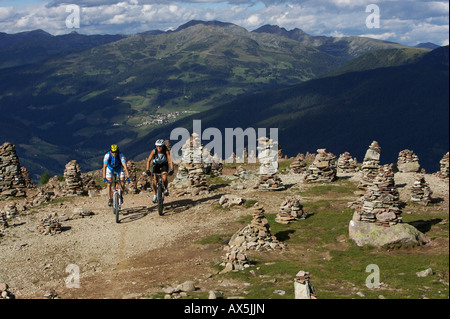 Weibliche und männliche Mountainbiker am Stoanernen Mandlen, Hohen Reisch, Nord-Italien, Europa Stockfoto